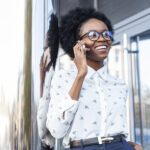 low angle smiley female talking phone